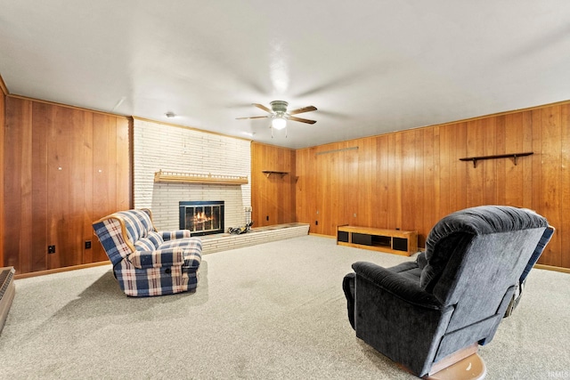 living room with ceiling fan, wooden walls, a fireplace, and light carpet