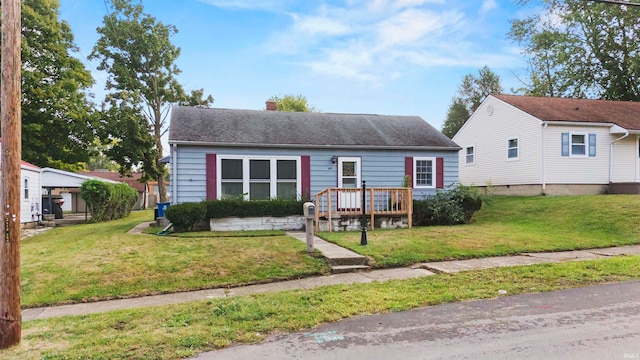 view of front facade with a wooden deck and a front yard