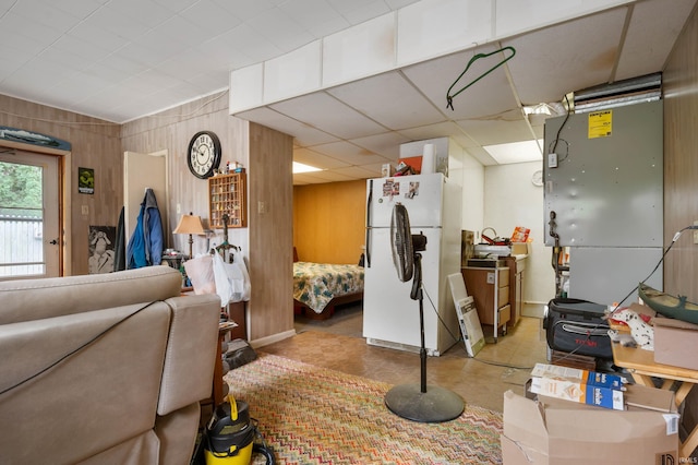 basement featuring wooden walls and white fridge