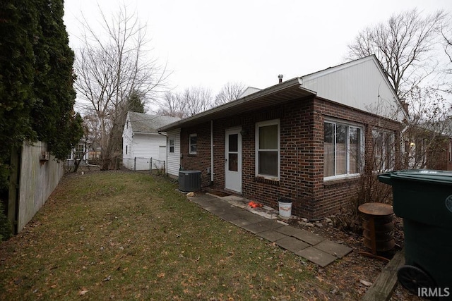 view of side of home with central air condition unit and a lawn