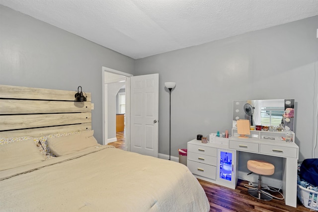 bedroom with dark hardwood / wood-style floors and a textured ceiling