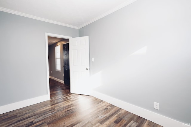 unfurnished room featuring dark wood-type flooring and ornamental molding