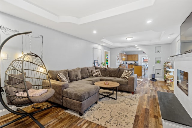 living room featuring hardwood / wood-style floors and a tray ceiling