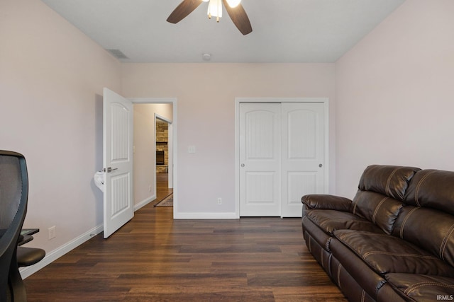 living room with ceiling fan and dark wood-type flooring