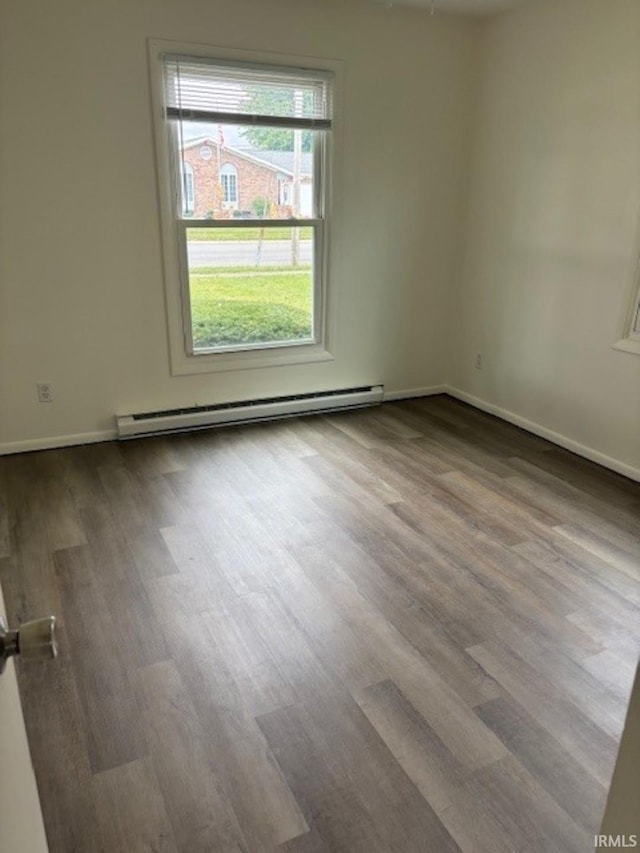 empty room featuring hardwood / wood-style flooring and baseboard heating