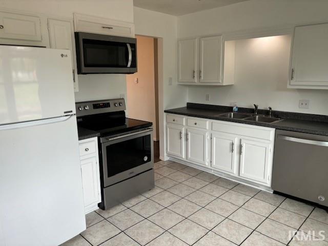 kitchen with appliances with stainless steel finishes, sink, and white cabinetry