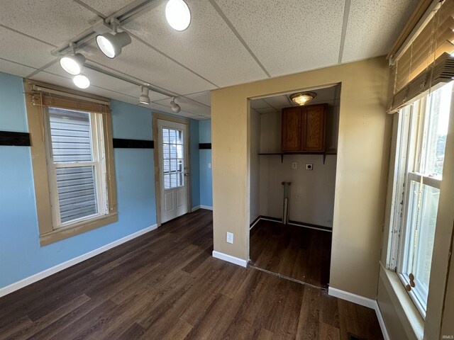 232 S Main St, Avilla, IN 46710 - unfurnished bedroom with rail lighting, dark wood-style floors, baseboards, and a paneled ceiling