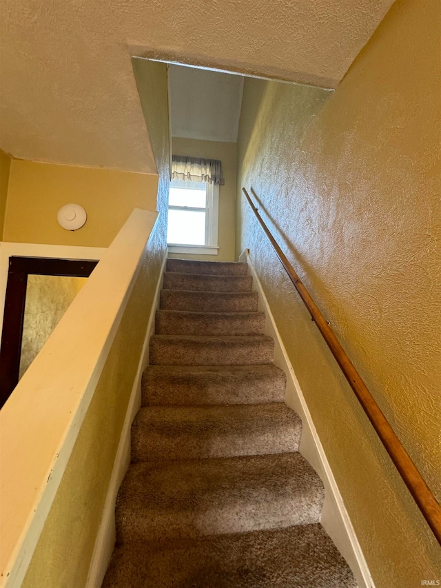 stairs with a textured ceiling