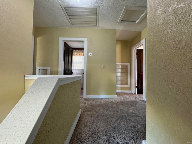 corridor with a textured ceiling and carpet