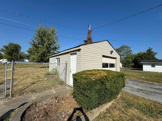 view of outdoor structure with a garage and a lawn