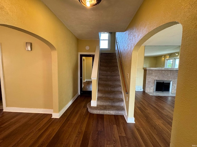 stairway featuring hardwood / wood-style flooring and a fireplace