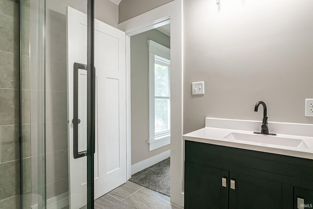 bathroom featuring a shower with door and vanity