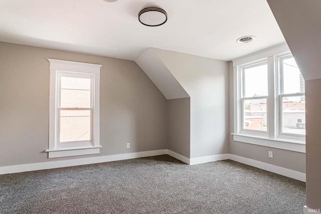 bonus room with carpet flooring and vaulted ceiling