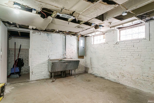 basement featuring electric panel and brick wall