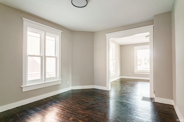 unfurnished room with plenty of natural light and dark wood-type flooring