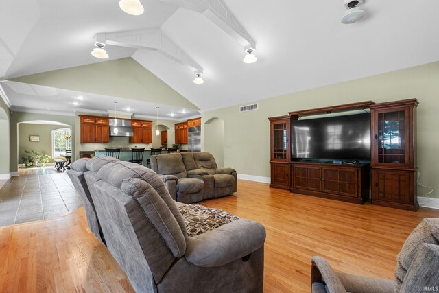 living room with high vaulted ceiling and light hardwood / wood-style floors