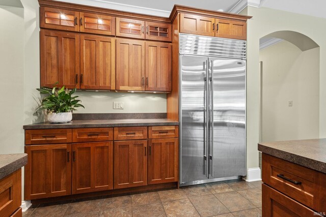 kitchen with stainless steel built in refrigerator and ornamental molding