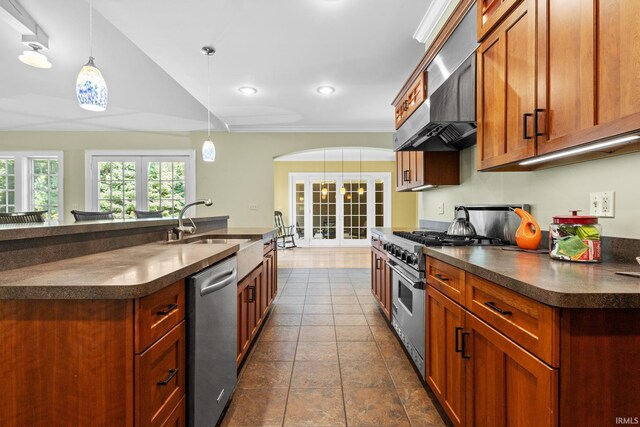 kitchen with sink, wall chimney exhaust hood, appliances with stainless steel finishes, decorative light fixtures, and french doors