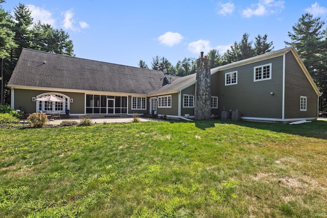 rear view of property with a lawn and a patio