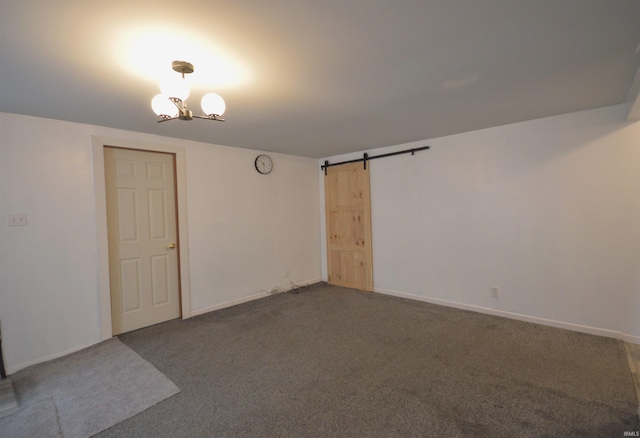 carpeted spare room featuring a barn door