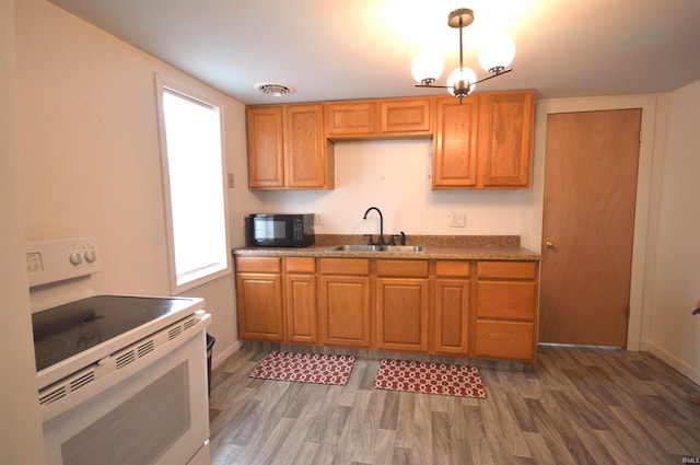 kitchen with white electric range, hanging light fixtures, dark hardwood / wood-style floors, and sink