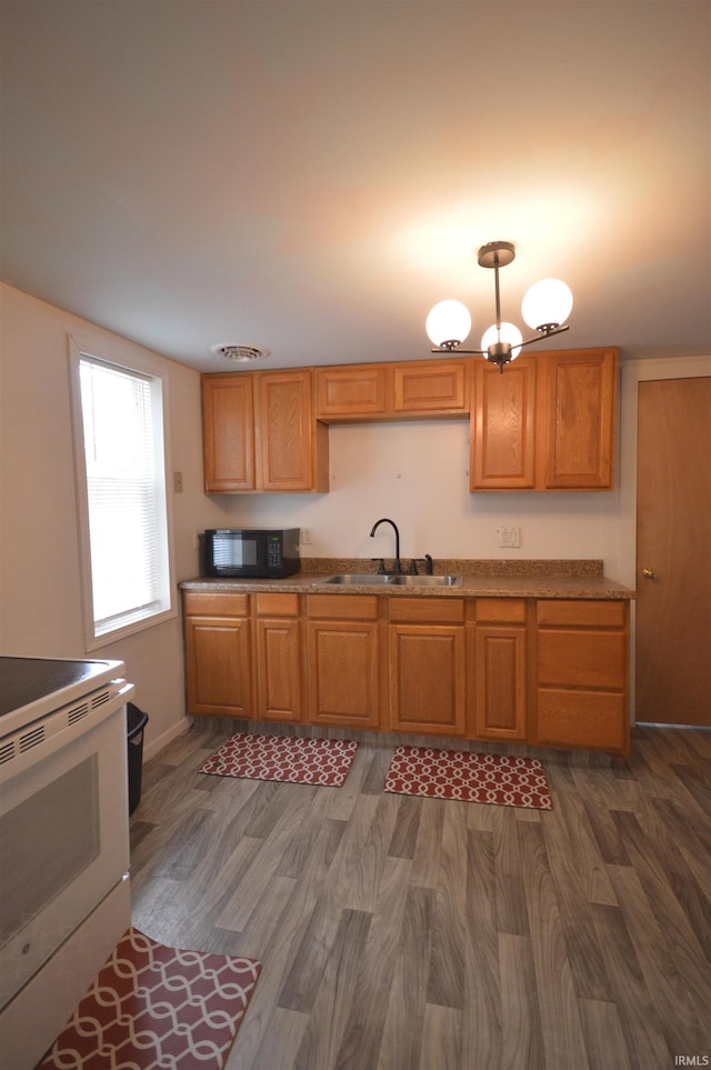 kitchen featuring an inviting chandelier, dark hardwood / wood-style floors, sink, and range