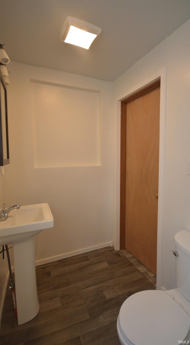 bathroom featuring toilet, sink, and hardwood / wood-style flooring