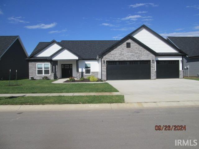 2159 Maple Leaf Dr, Kokomo, IN 46902 - view of front of house featuring a garage, stone siding, driveway, and a front lawn