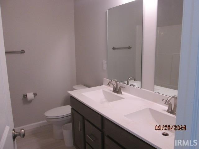 bathroom with hardwood / wood-style floors, vanity, and toilet