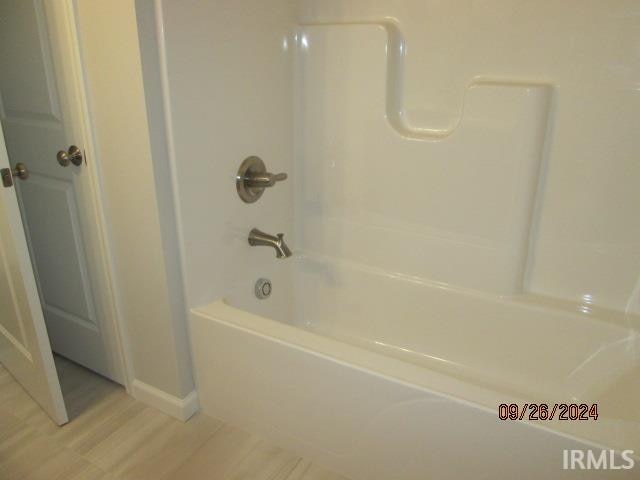 bathroom with shower / bath combination and hardwood / wood-style flooring