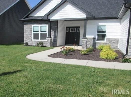 view of exterior entry with a lawn