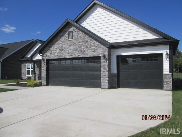 2159 Maple Leaf Dr, Kokomo, IN 46902 - view of front facade featuring an attached garage, stone siding, and concrete driveway
