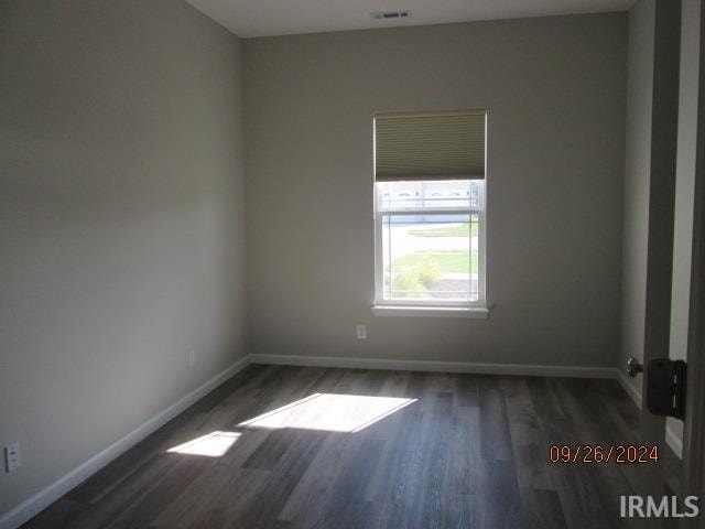 unfurnished room featuring dark wood-type flooring