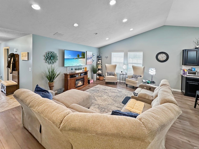 living room featuring light hardwood / wood-style flooring and vaulted ceiling