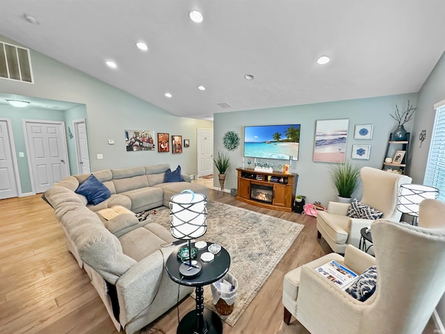 living room featuring vaulted ceiling and light hardwood / wood-style flooring