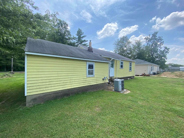 back of property with a yard and central air condition unit