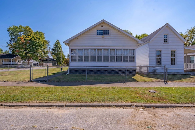 bungalow-style house featuring a front lawn and a sunroom