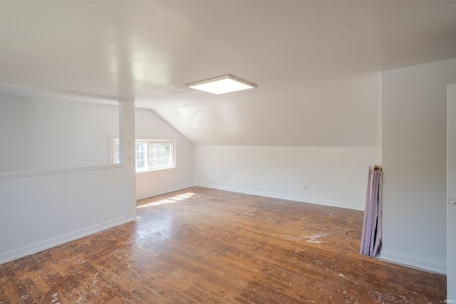 additional living space featuring wood-type flooring and vaulted ceiling