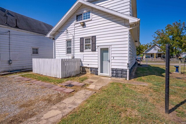 rear view of property featuring a lawn