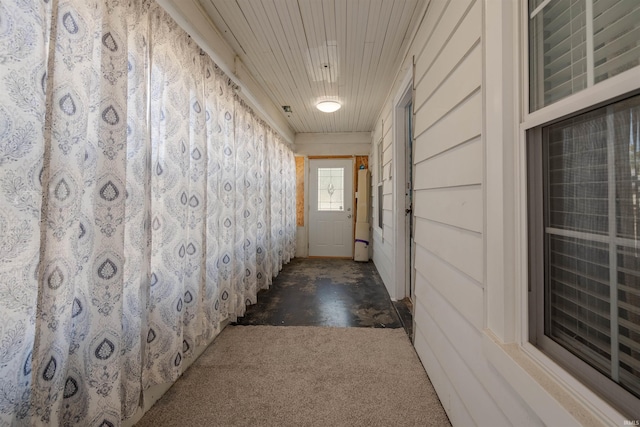 hallway featuring wooden ceiling and dark colored carpet