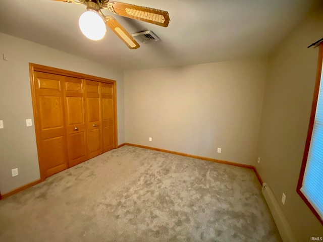 unfurnished bedroom with a baseboard radiator, a closet, carpet, and ceiling fan