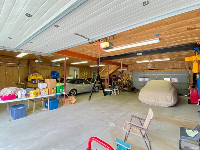 garage with a garage door opener and wood walls