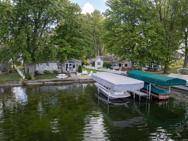 dock area with a lawn and a water view