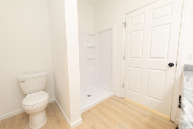 bathroom with toilet, walk in shower, and hardwood / wood-style flooring