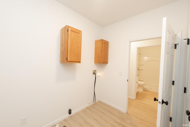 washroom featuring light hardwood / wood-style floors, washer hookup, and cabinets