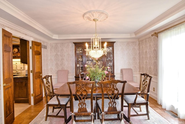 dining area with an inviting chandelier, light parquet floors, and crown molding