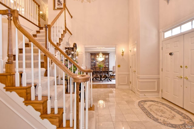 entryway with a towering ceiling and a chandelier