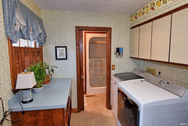 laundry area with separate washer and dryer, cabinets, and light tile patterned flooring