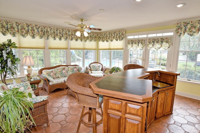 sunroom with a wealth of natural light, ceiling fan, and sink