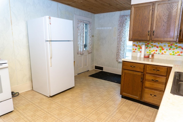 kitchen featuring wood ceiling, a wealth of natural light, and white appliances